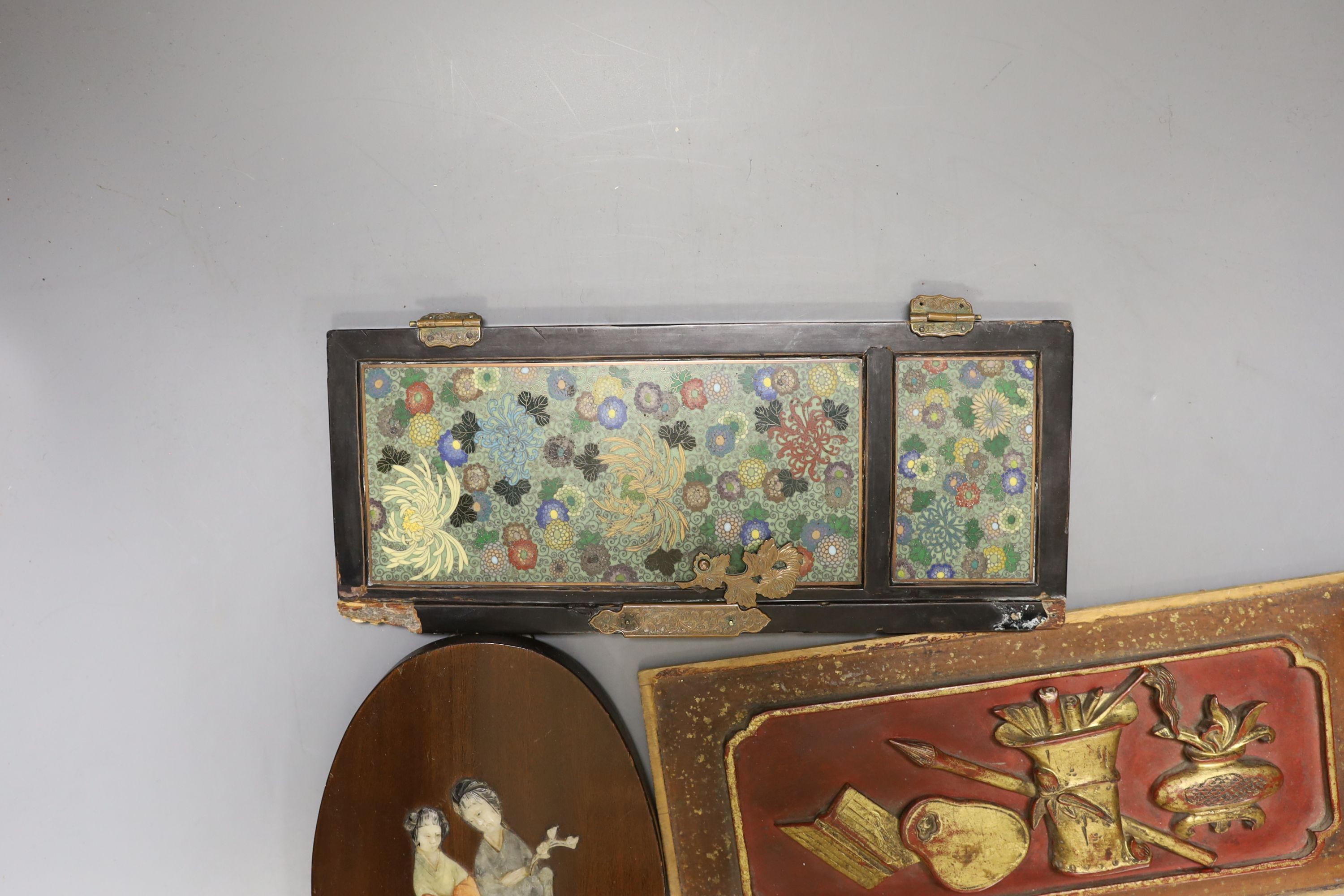A Japanese Cloisonné enamel panelled cabinet door, 25.5 cm high, a Chinese lacquered wood panel, 26.5 X 12 cm and a Chinese soapstone in laid hardwood panel depicting two ladies, 20 cm high